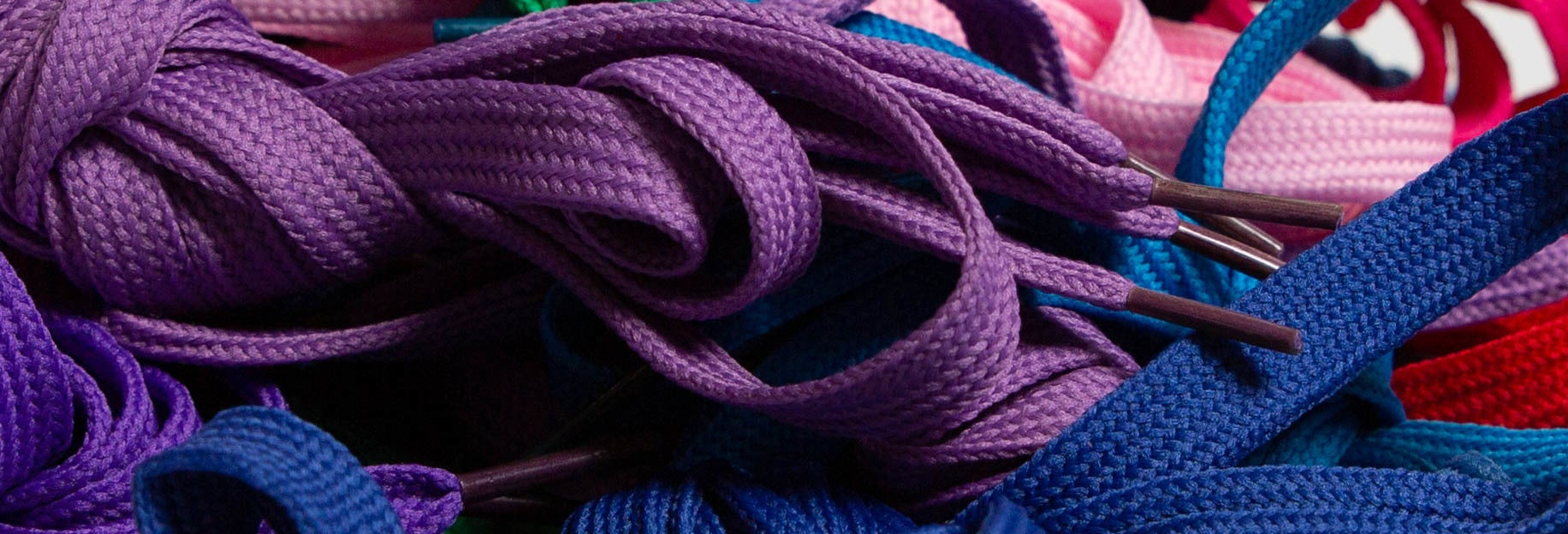 Close-up of colorful shoelaces in purple, blue, and red.